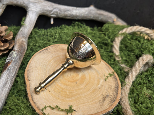 Metallinen alttarikello pentagram kuviolla.