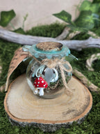 Loitsupullon sisältö: sammal, käpy, jäkälä, katajanmarja, sammalakaatti, käärmeen nahka, sanianen, ametisti