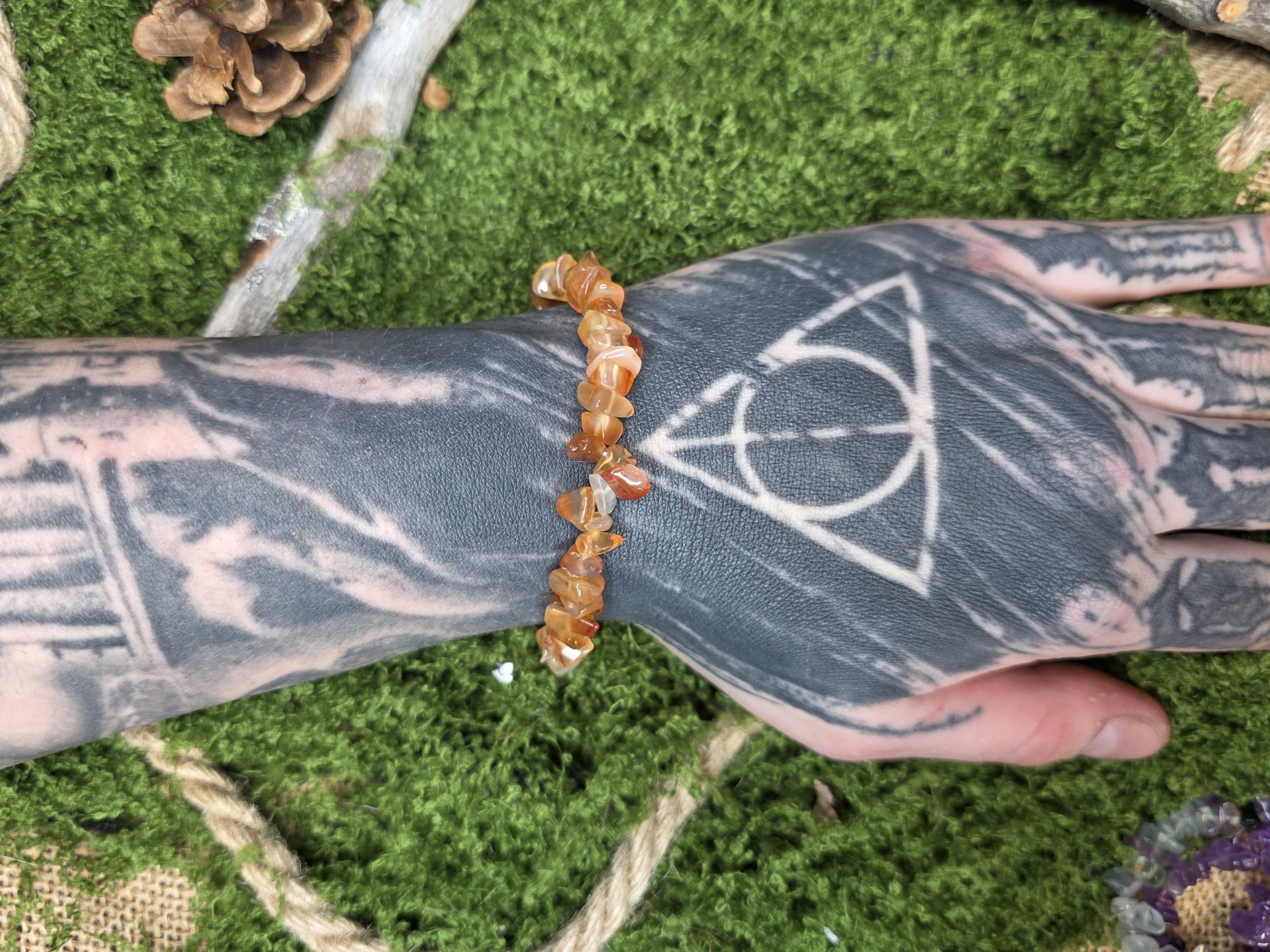 Karneoli kivisiruista valmistettu rannekoru mallin kädessä. 