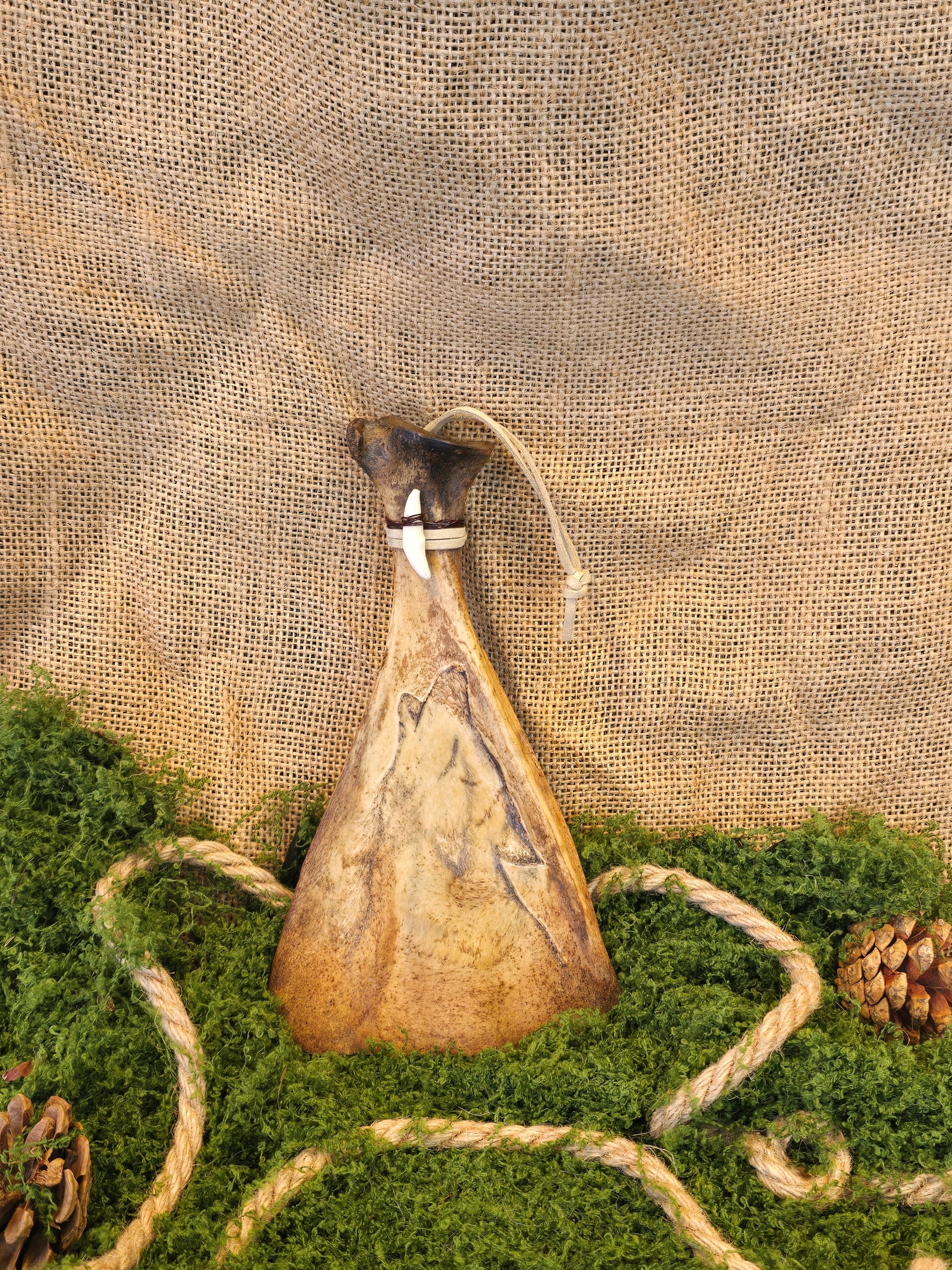 Kauriin lapaluu koriste, jossa ketunhammas ja polttokuvioitu susi.