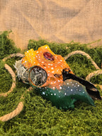 Kauriin kallo, joka on huolellisesti käsitelty ja koristeellisesti maalattu. Siihen on upotettu dragon's eye kivi.