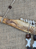 Kauriin leukaluusta, saniaisista, sulista, luusta tehty seinäkoriste. Lähikuva yksityiskohdista.