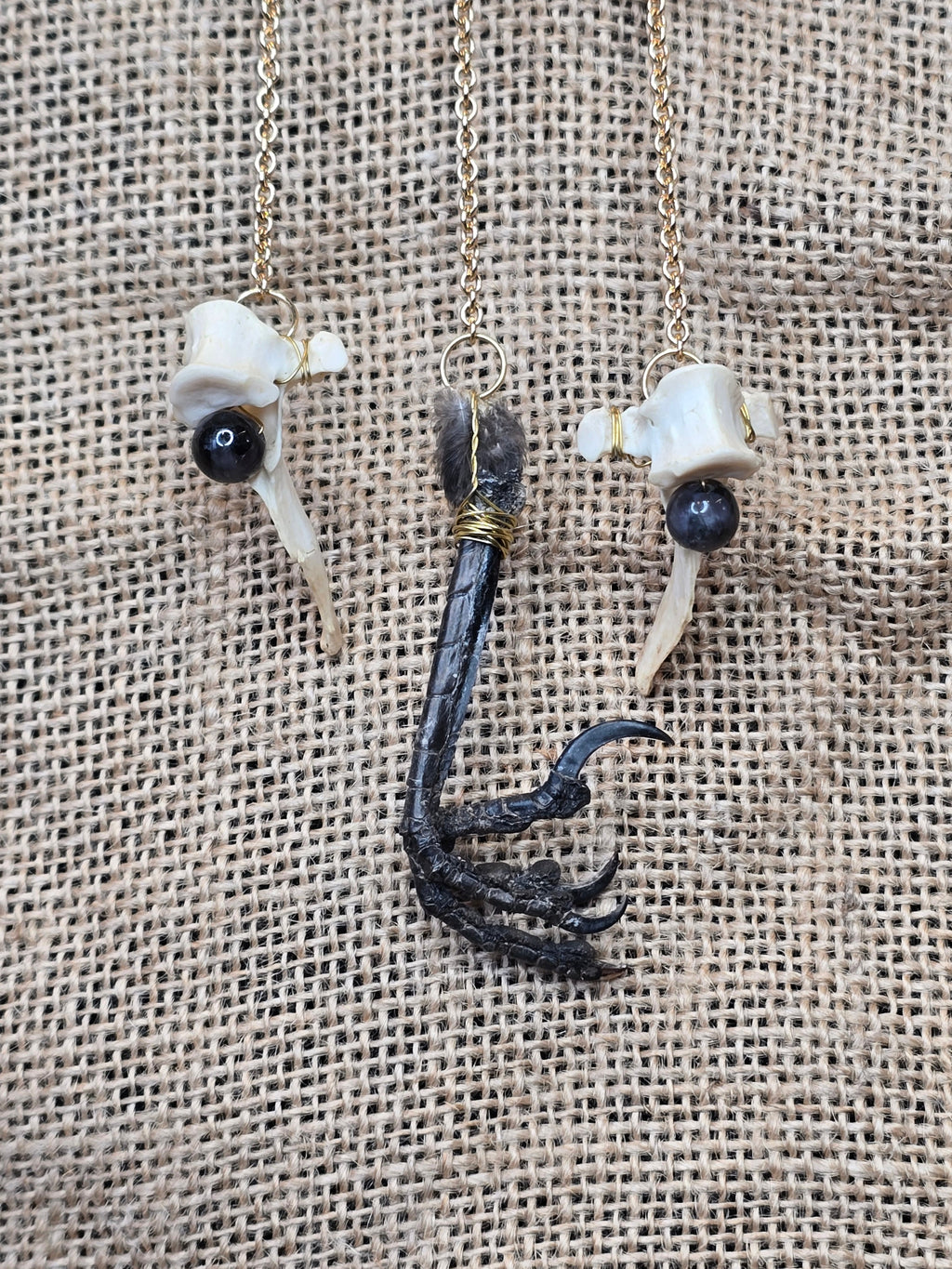 Kauriin leukaluu seinäkoriste, Lilith symbolilla. Koristeen yksityiskohdista kuva mm. naakan jalka.