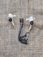 Kauriin leukaluu seinäkoriste, Lilith symbolilla. Koristeen yksityiskohdista kuva mm. naakan jalka.