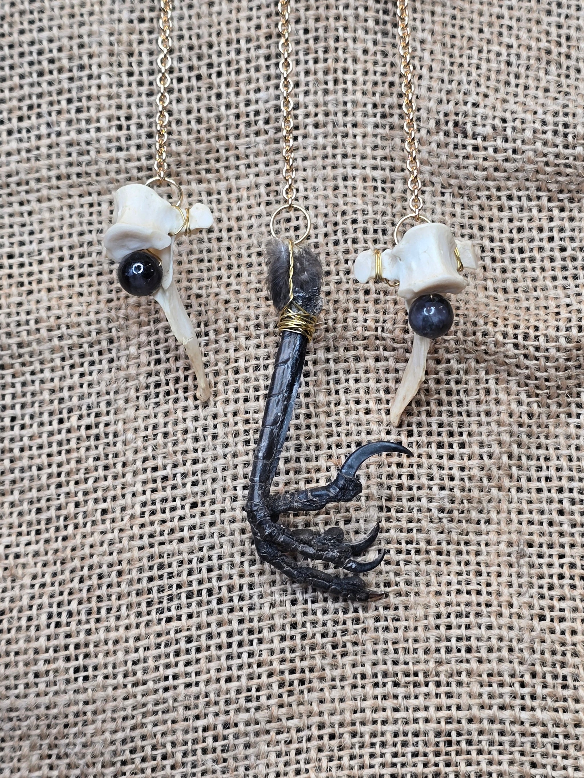 Kauriin leukaluu seinäkoriste, Lilith symbolilla. Koristeen yksityiskohdista kuva mm. naakan jalka.