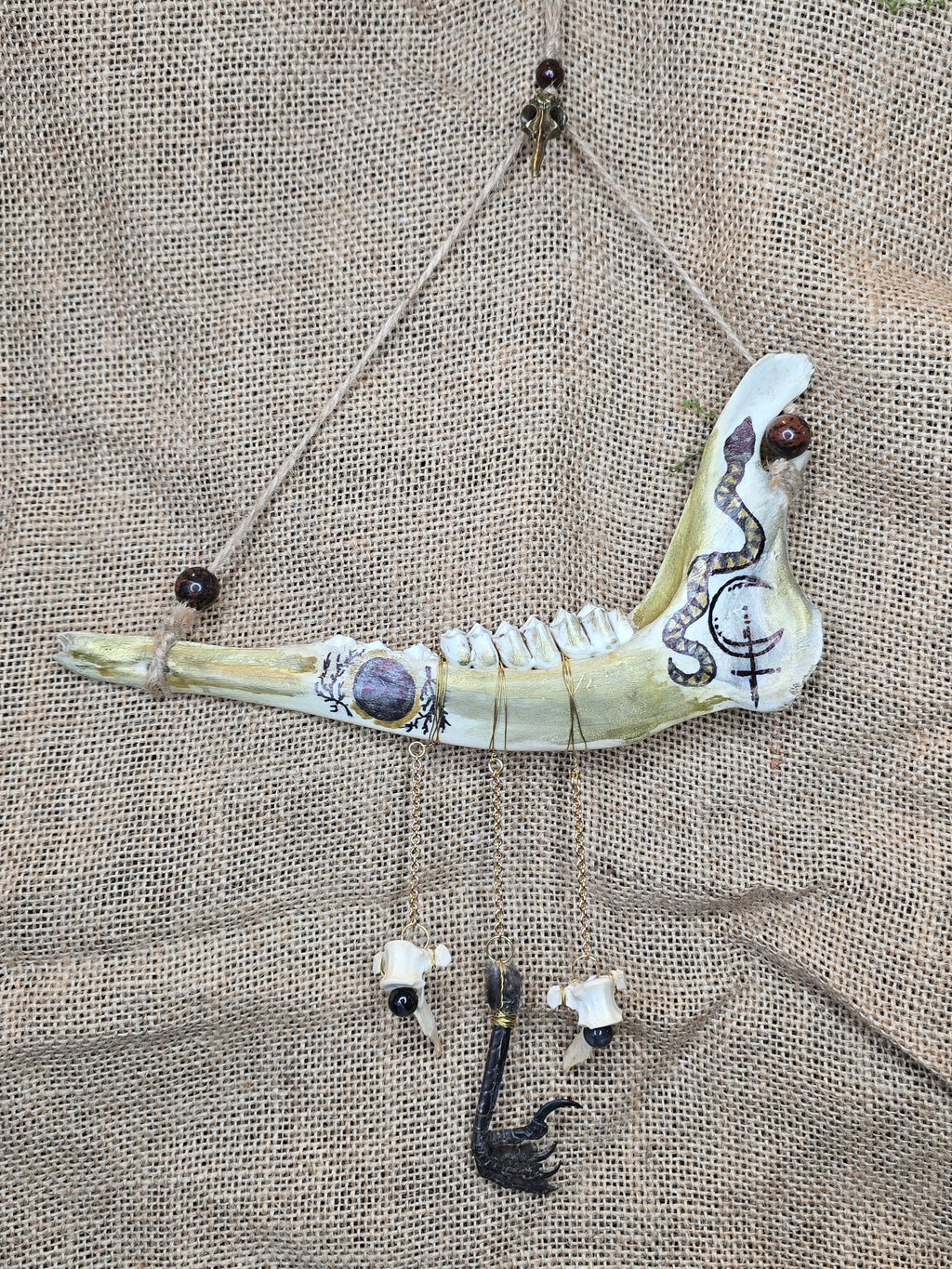 Kauriin leukaluu seinäkoriste, Lilith symbolilla. 