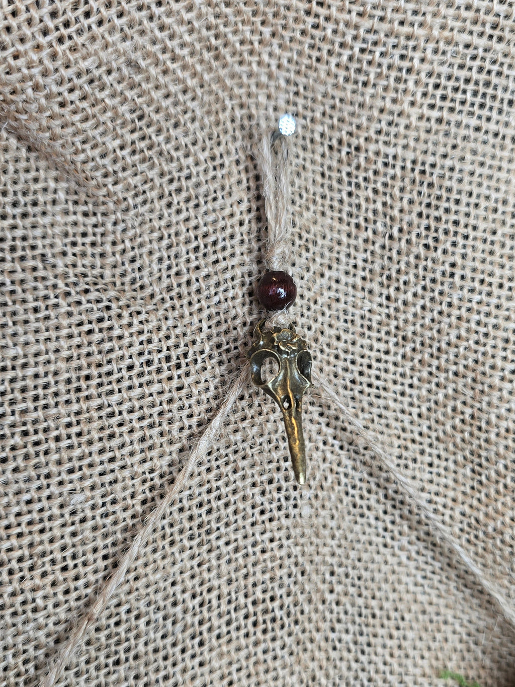 Kauriin leukaluu seinäkoriste, Lilith symbolilla. Lähikuva seinäkiinnityksestä.