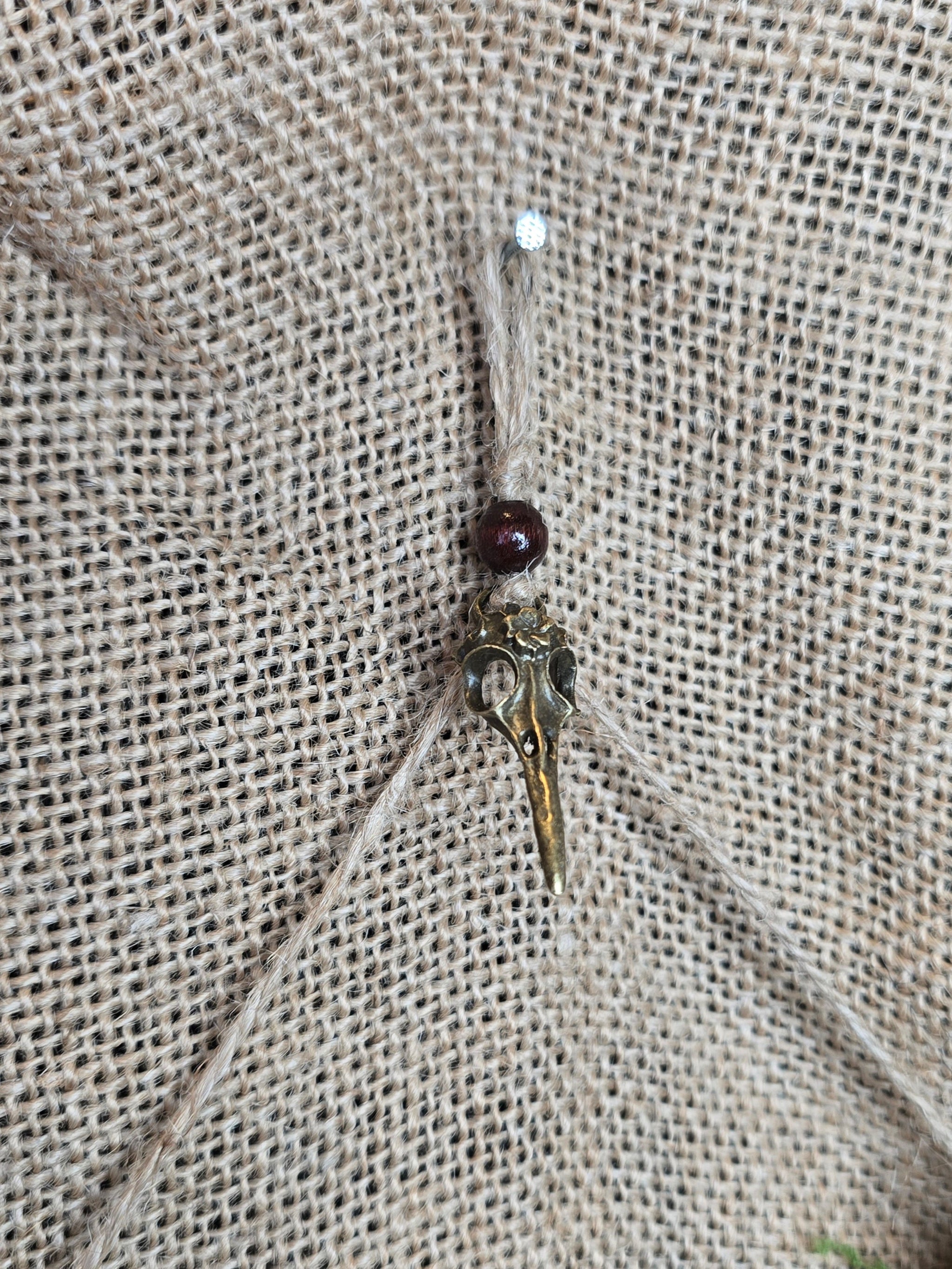 Kauriin leukaluu seinäkoriste, Lilith symbolilla. Lähikuva seinäkiinnityksestä.