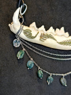 Ketunleukaluusta valmistettu kaulakoru, koristeltu sammalein ja sammalakaattihelmillä. Lähikuva korun yksityiskohdista.