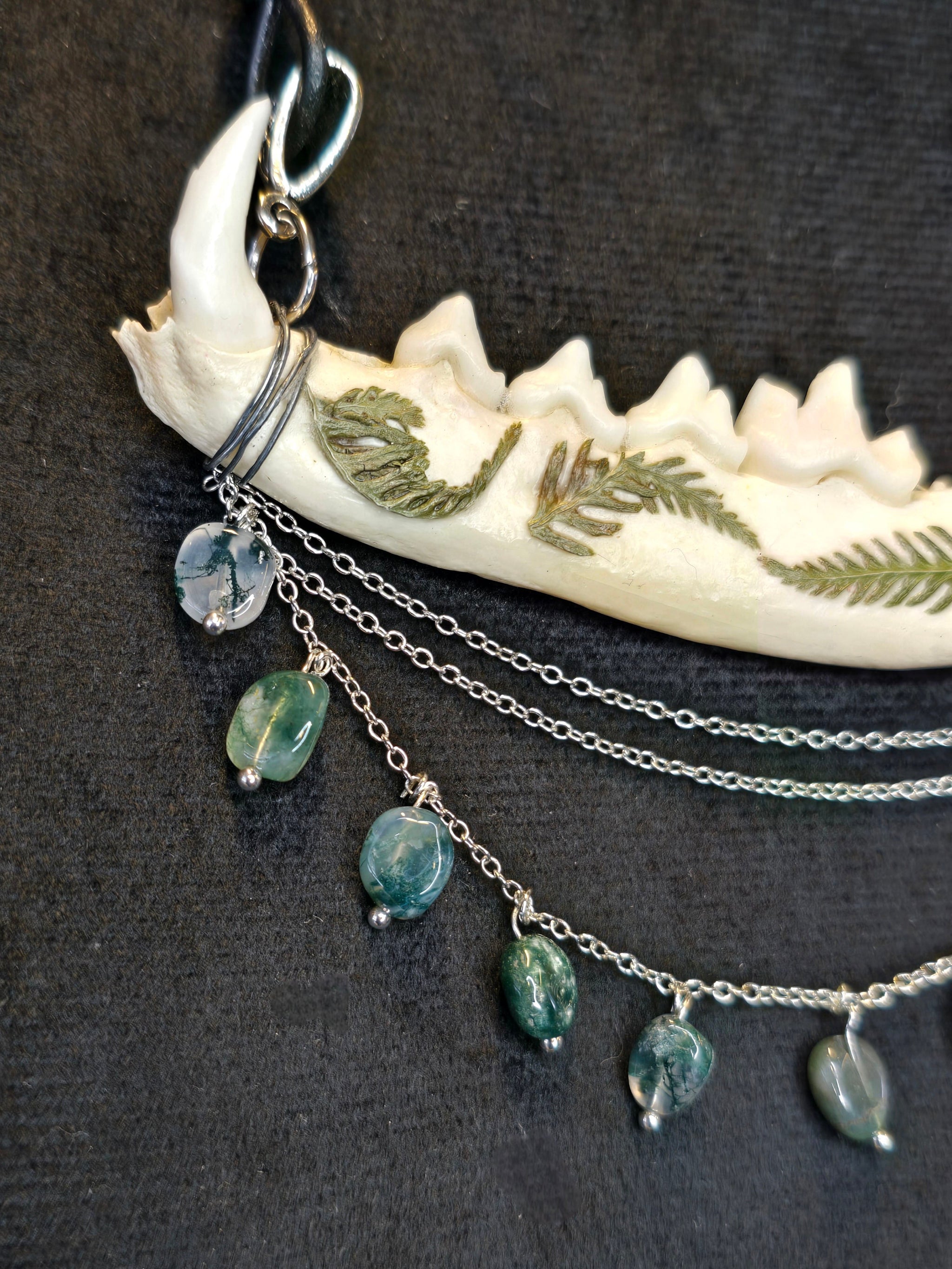 Ketunleukaluusta valmistettu kaulakoru, koristeltu sammalein ja sammalakaattihelmillä. Lähikuva korun yksityiskohdista.