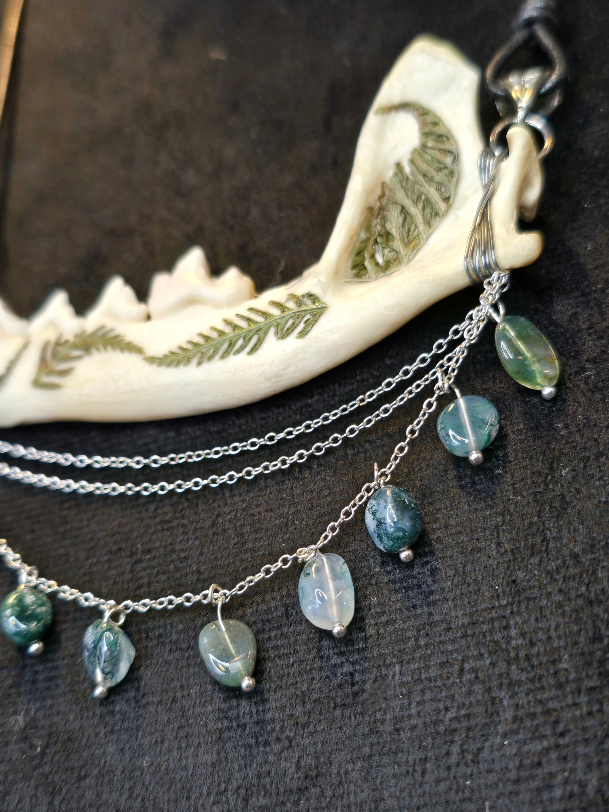 Ketunleukaluusta valmistettu kaulakoru, koristeltu sammalein ja sammalakaattihelmillä.Lähikuva yksityiskohdista.