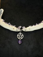 Ketun leukaluista, ametistisiruista tehty kaulakoru pentagram riipuksella. Lähikuva riipuksesta.