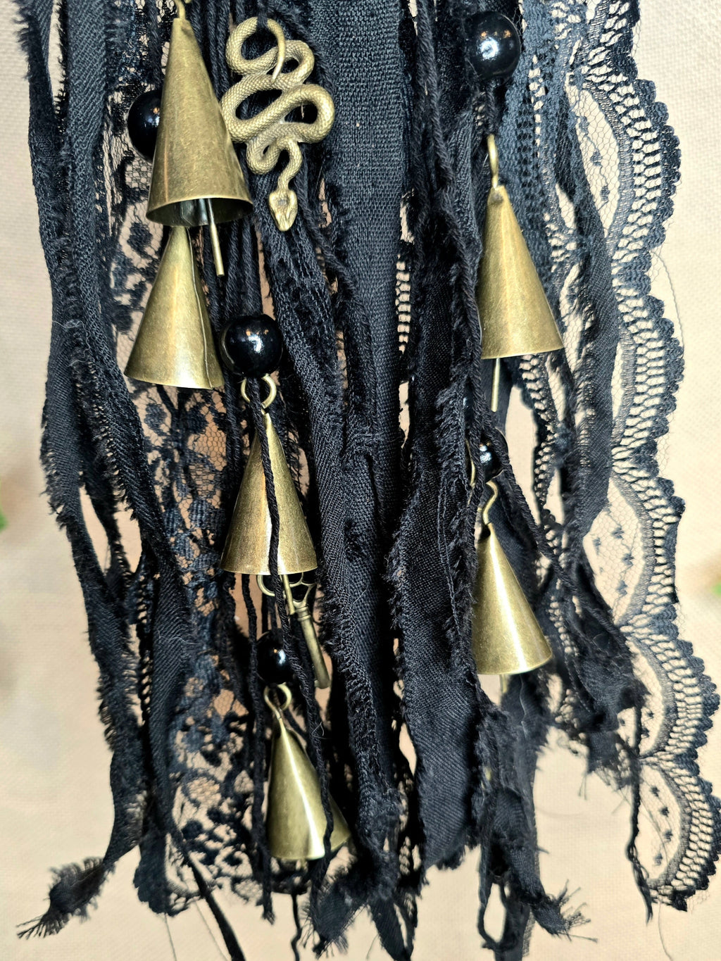 Musta noitakello, jossa kullanväristen kellojen lisäksi käärme ja triquetra symbolit.