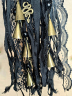 Musta noitakello, jossa kullanväristen kellojen lisäksi käärme ja triquetra symbolit.