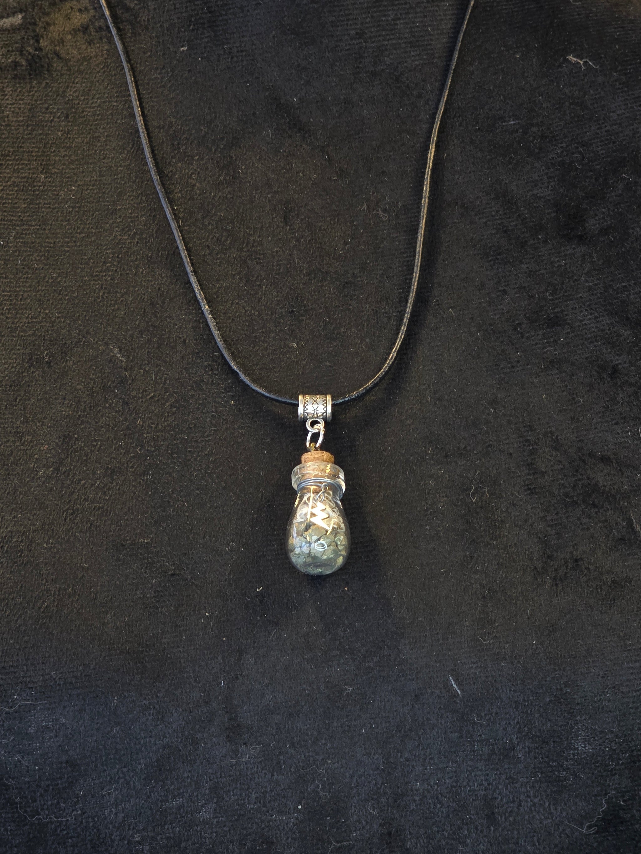 Kaulakoru, jossa lasipulloriipuksen sisällä kuningasboan luontinahkaa ja pyriittiä. Salamariipus somiste. 