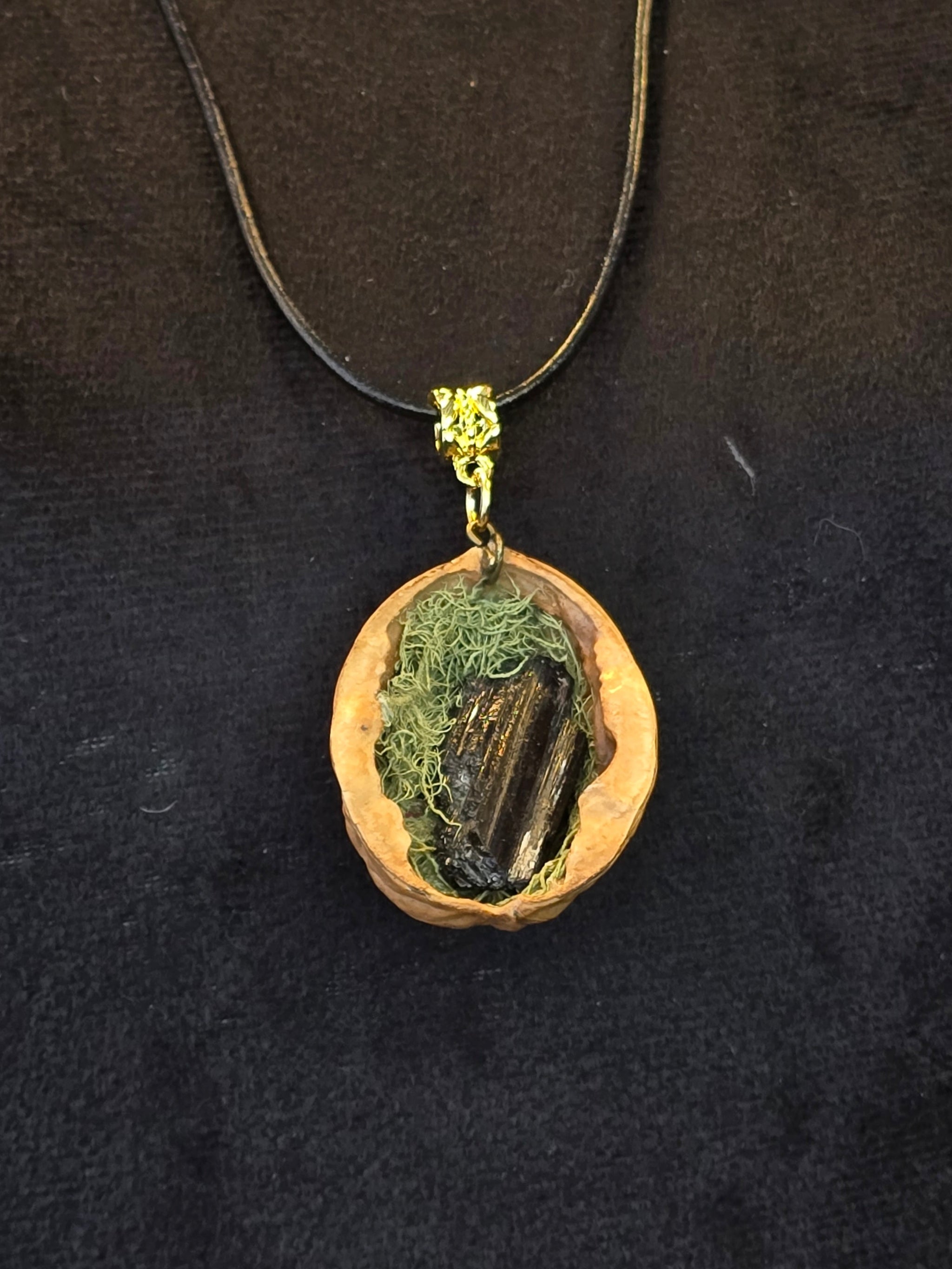 Kaulakoru, joka on valmistettu saksanpähkinän kuoresta, sammaleesta ja turmaliinista. 