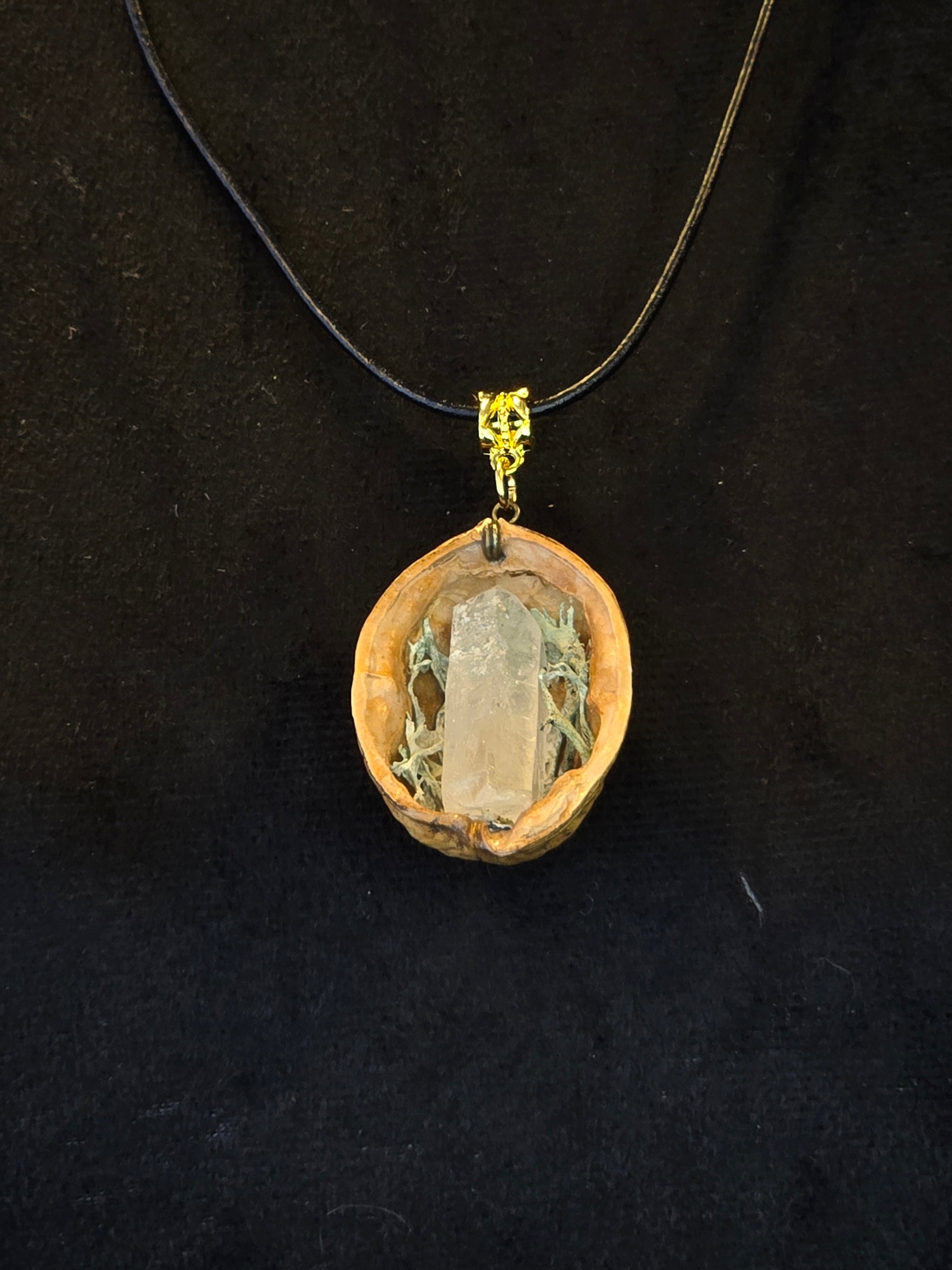 Kaulakoru, joka on valmistettu saksanpähkinänkuoresta, jäkälästä ja vuorikristallista. 