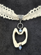 Käsityönä valmistettu pitsichoker kaulakoru, poronluu-angeliittihelmi riipuksella. Lähikuva porunluisesta riipuksesta. Inked Mystiqs verkkokaupasta. Kuunjuurella valmistama.