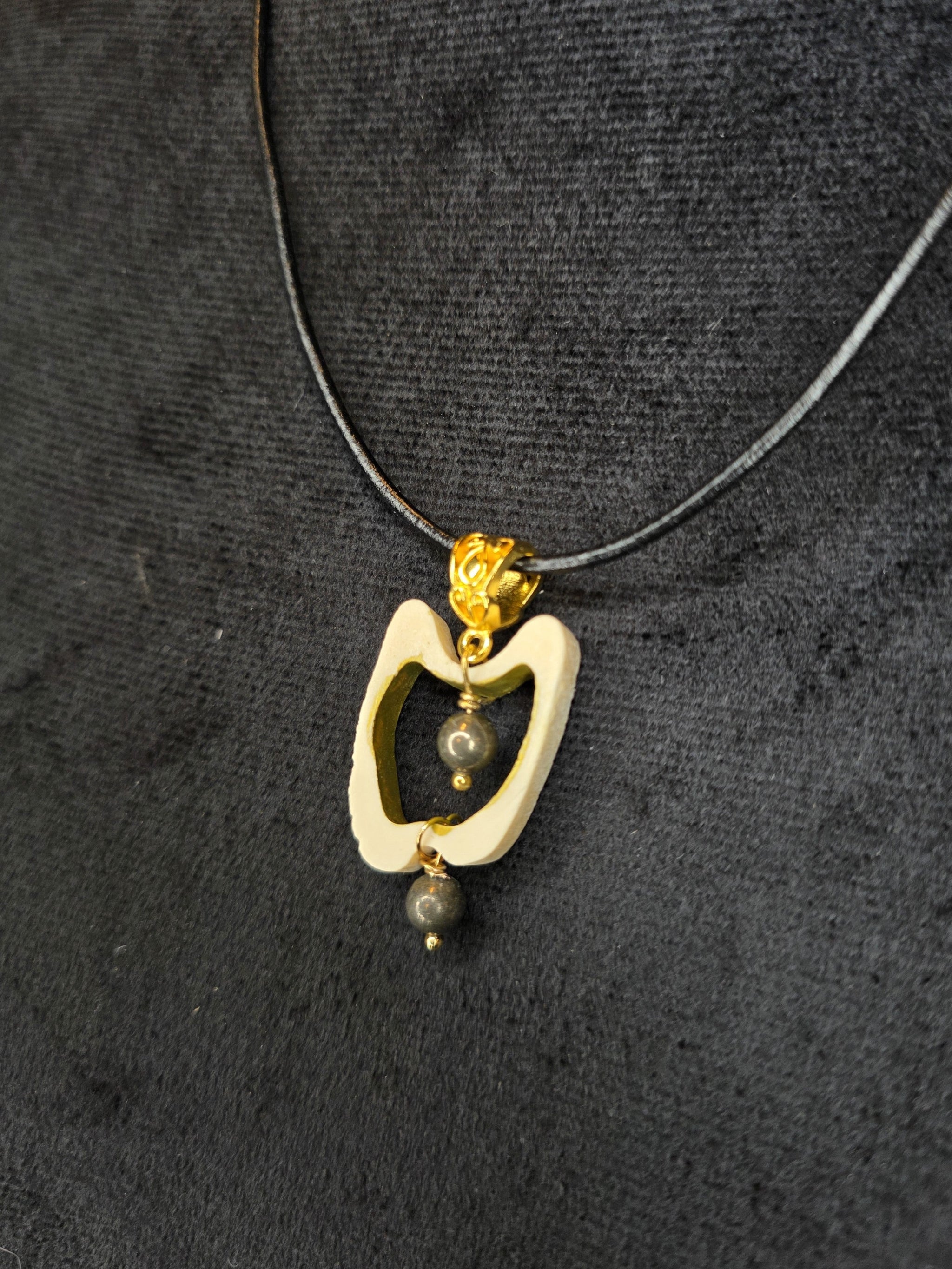 Poronluusta valmistettu kaulakoru, jossa keskellä pyriittihelmiä.