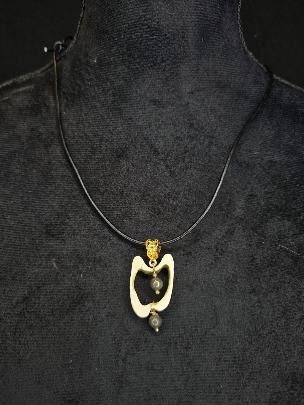 Poronluusta valmistettu kaulakoru, jossa keskellä pyriittihelmiä. 