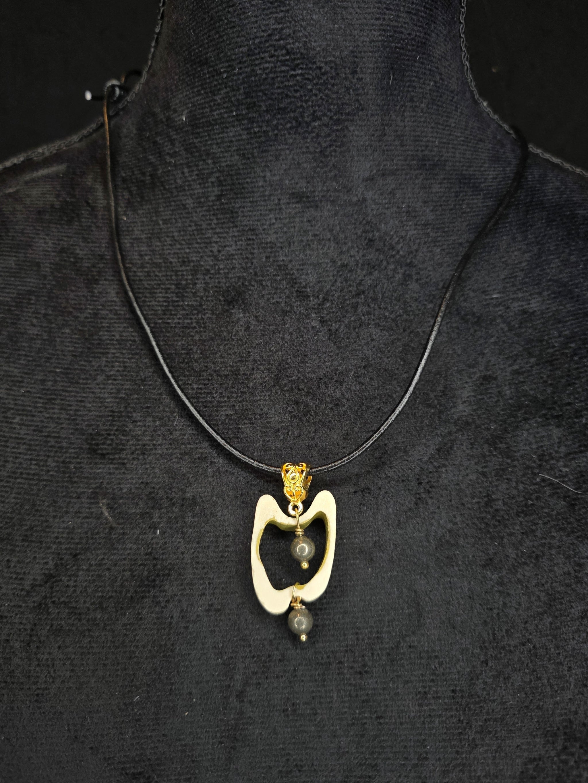 Poronluusta valmistettu kaulakoru, jossa keskellä pyriittihelmiä. 