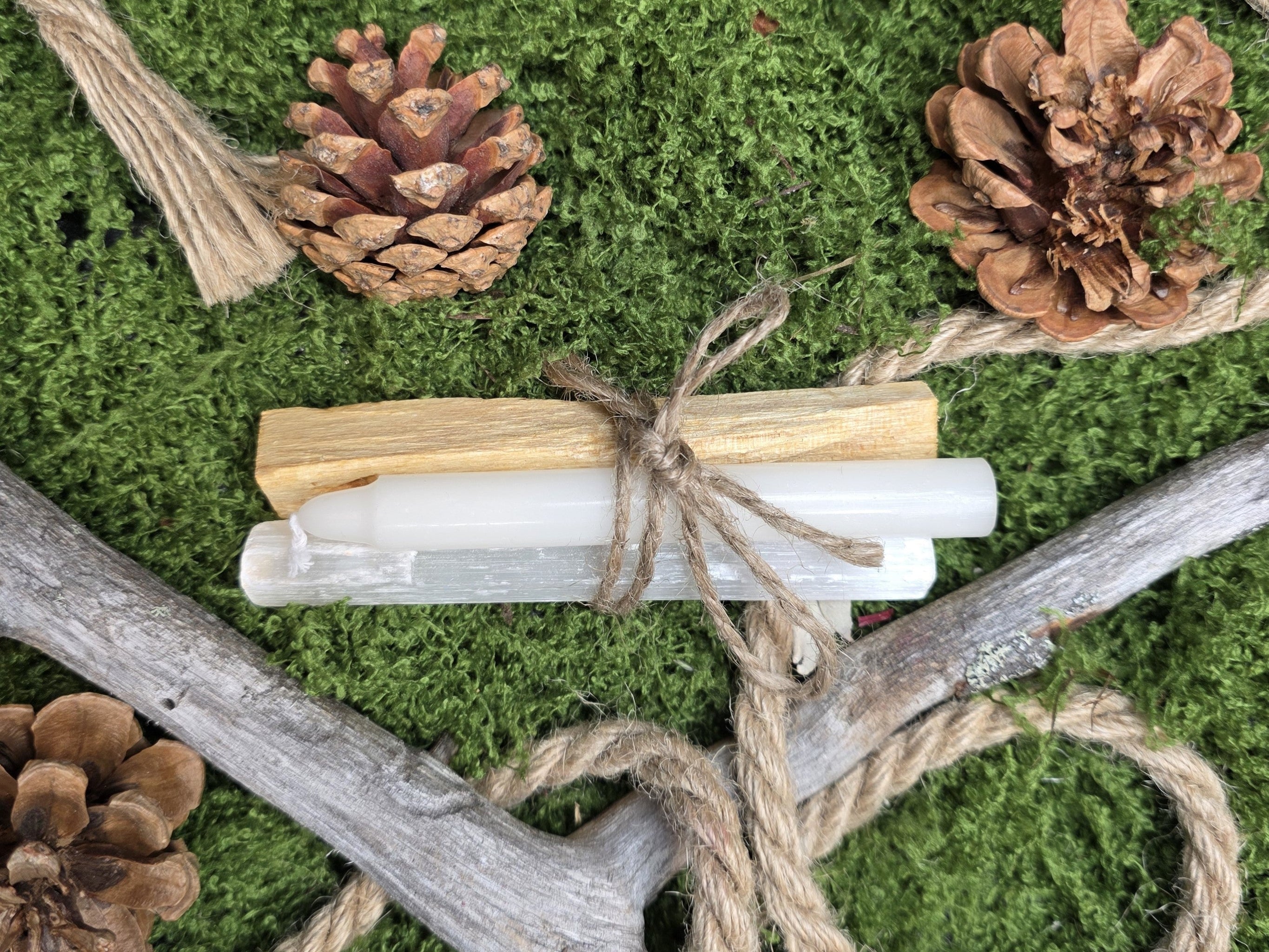 Puhdistuspakkaus, joka sisältää valkoisen loitsukynttilän, palo santo-suitsukkeen ja seleniitti tikun.