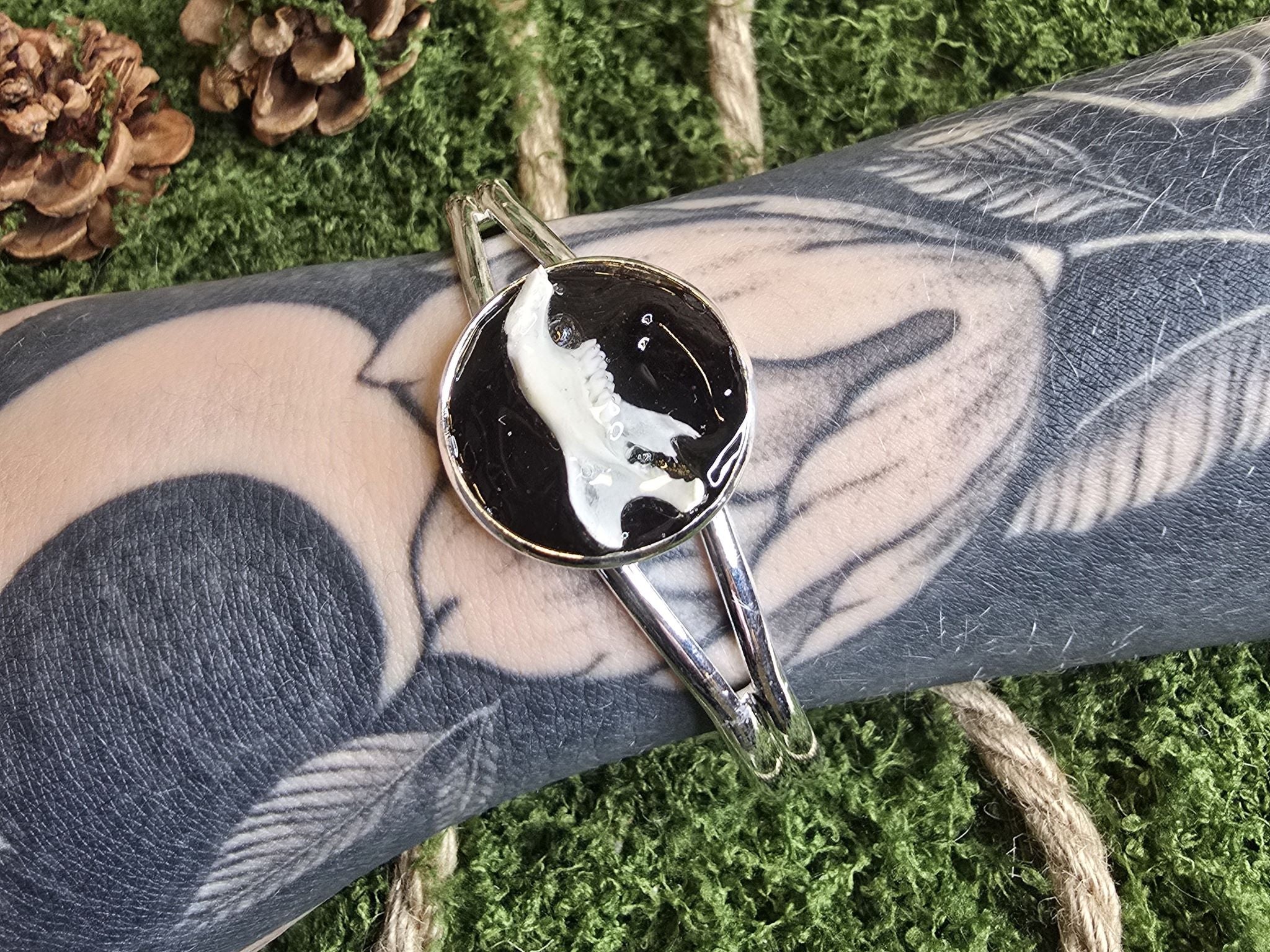 Säädettävä rannekoru, jossa on rotan leukaluu mustaksi värjättyä lohennahkaa vasten. 