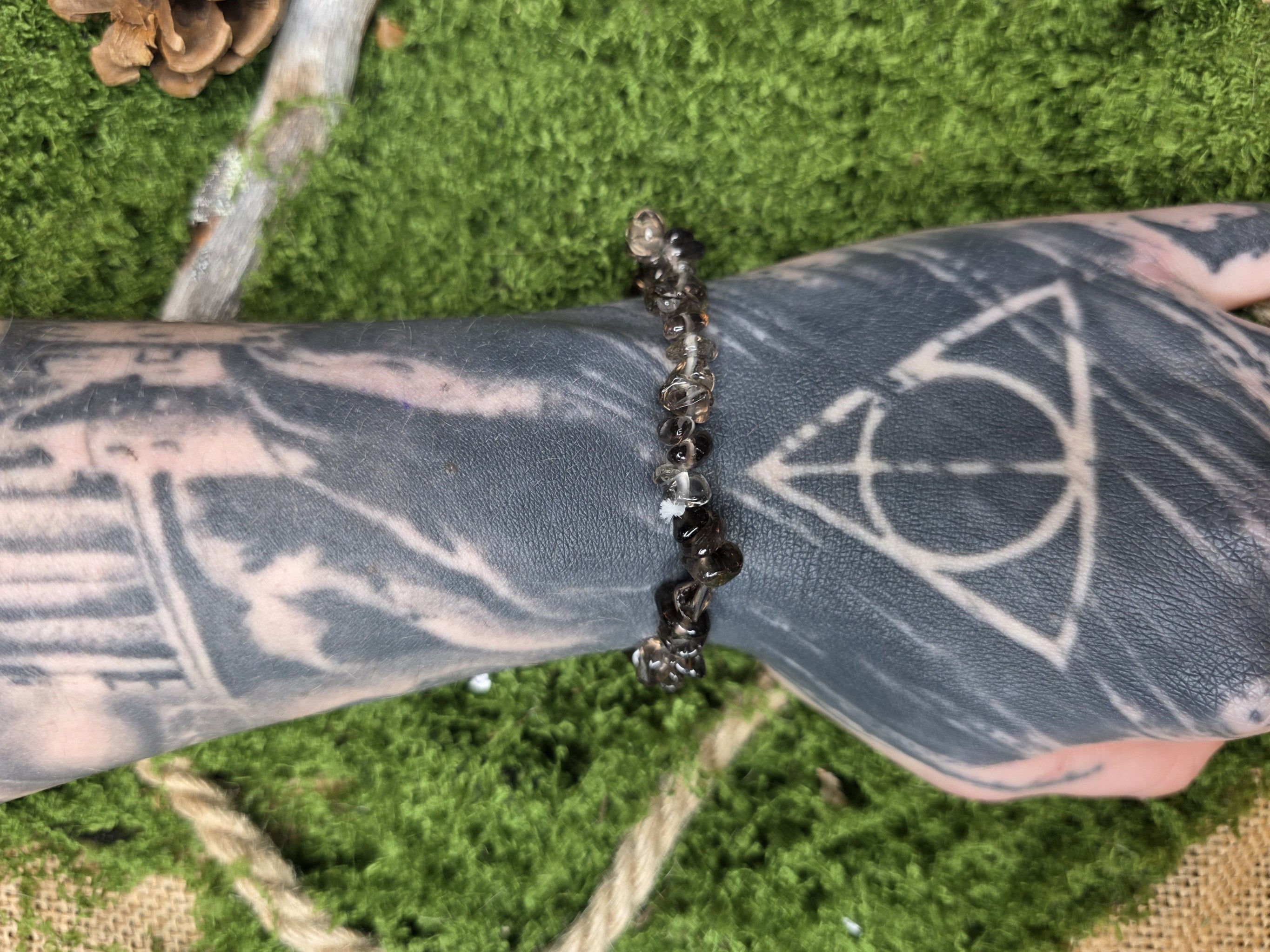 Savukvartsi kivisiruista valmistettu rannekoru mallin kädessä. 