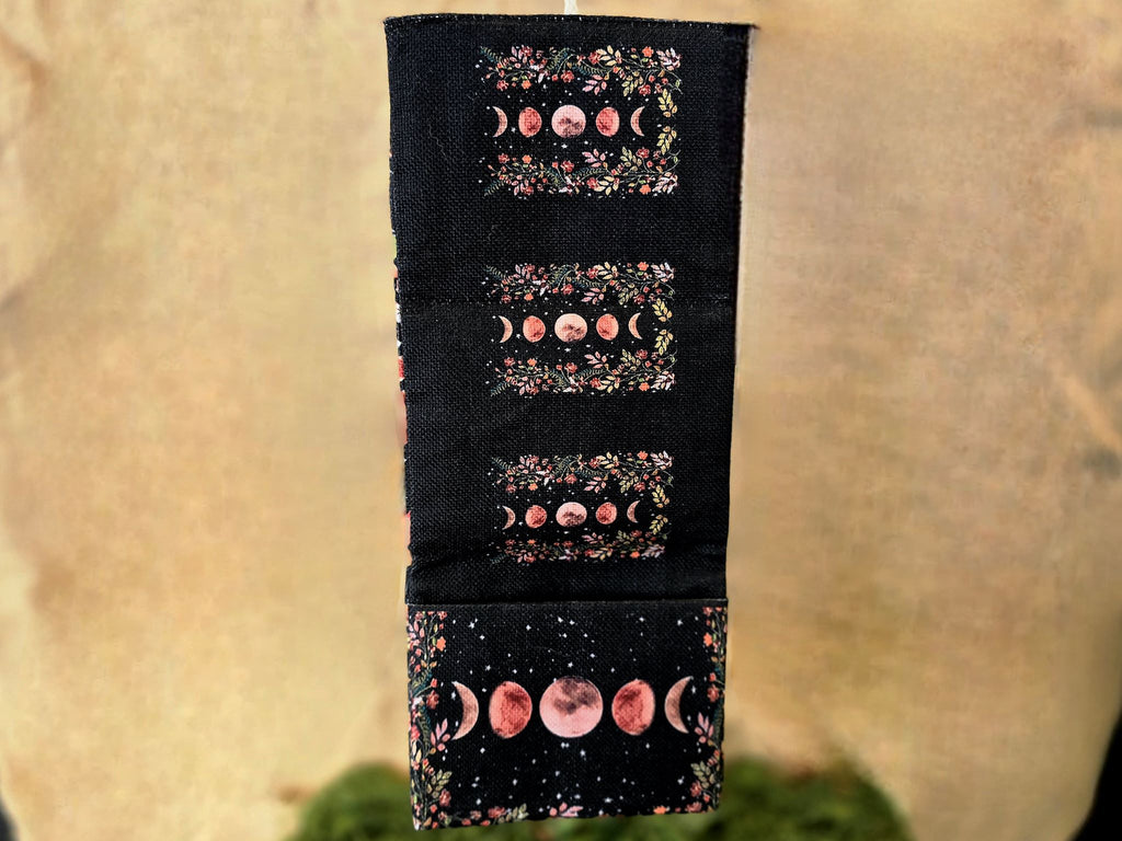 Tarot korttien musta säilytyspussi, johon kuvattu kuunvaiheet.