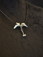 Kaulakoru, jossa thorin vasara symboli ja variksen nikamat. 