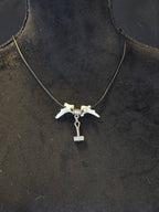 Kaulakoru, jossa thorin vasara symboli ja variksen nikamat. 