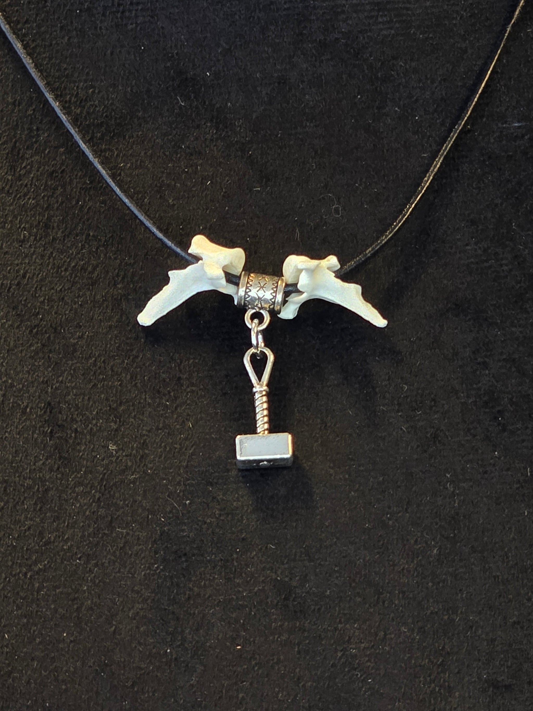 Kaulakoru, jossa käytetty variksen nikamia, ja thorin vasara symboli. 