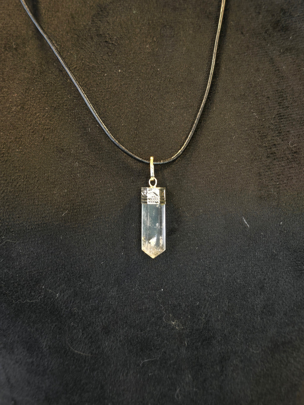 Vuorikristalli riipus nahkanauhassa.