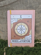 Tarot korteista tuttu wheel of fortune muistikirjana takaa.