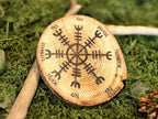 Puukiekosta valmistettu heilurialusta, jossa Vegvísir symboli.