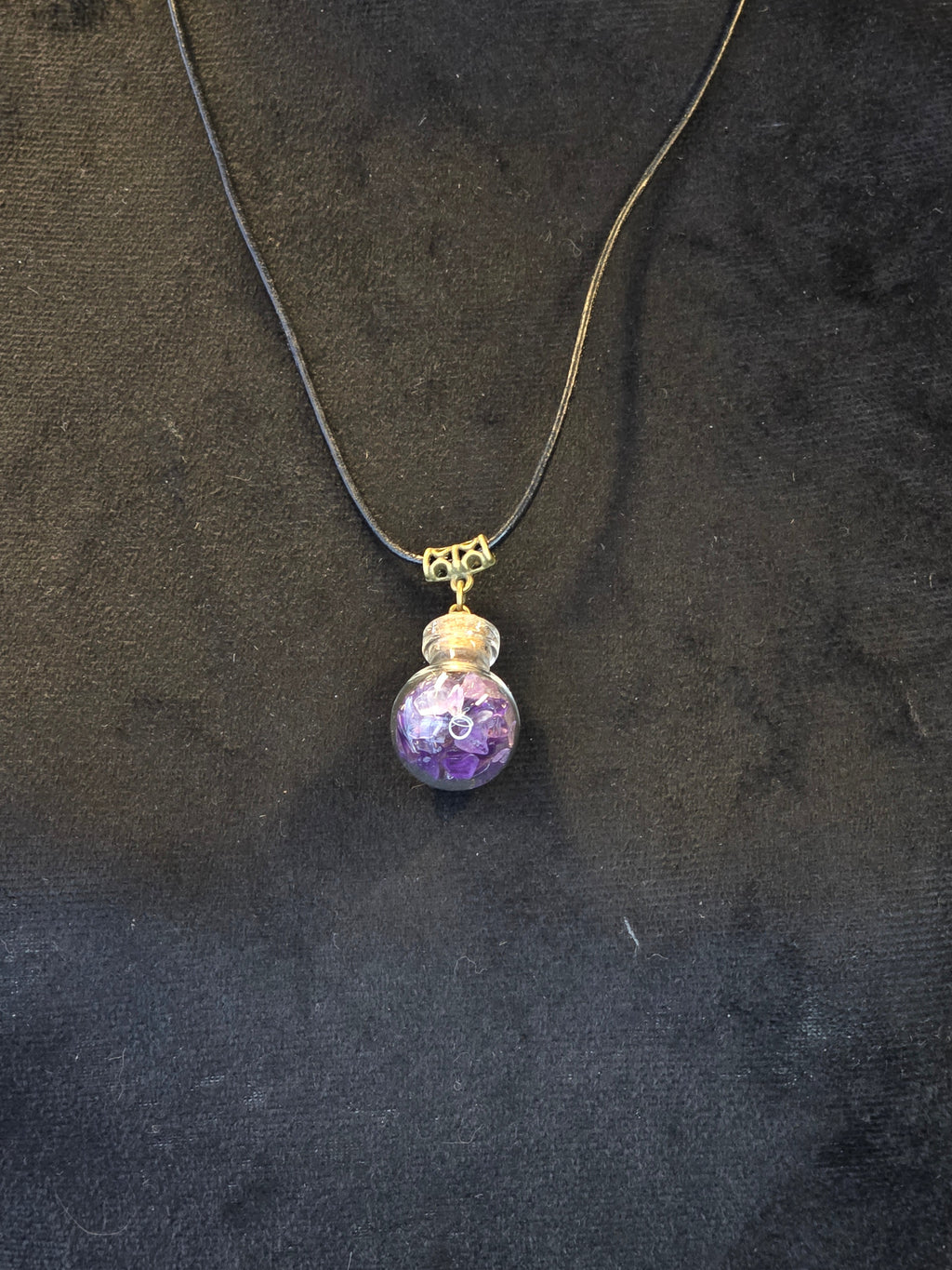 Lasipulloriipus, jonka sisällä ametistisiruja.