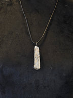 Vuorikristalli, johon on kuvioitu hopealangalla elämänpuusymboli. Kaulakoru. 