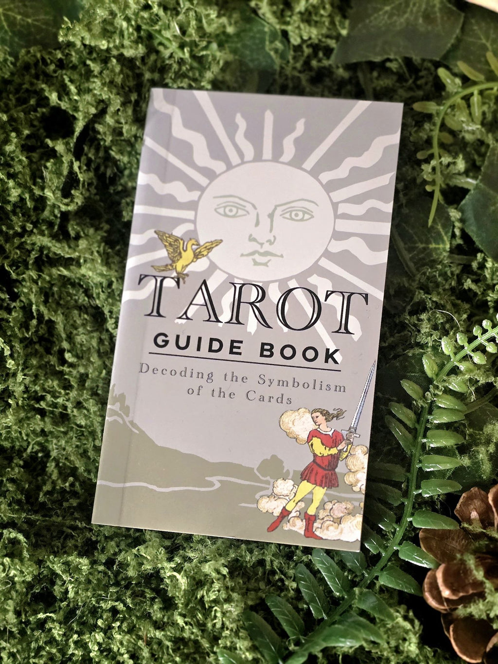 Musta-kultaiset perinteiset tarotkortit ja opaskirja.