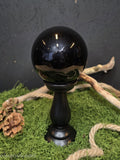 Musta kristallipallo mustalla puisella jalustalla. 