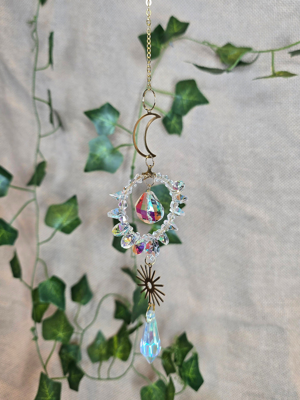 Aurinkosieppari, kuu ja aurinko, keskellä kristallikoriste.