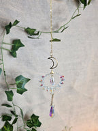 Aurinkosieppari, kuu ja aurinko, keskellä kristallikoriste.