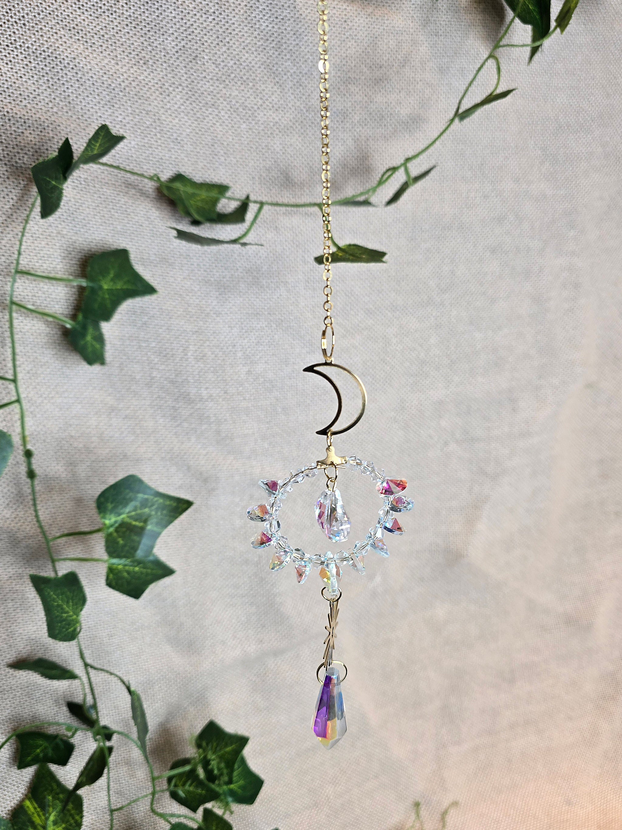 Aurinkosieppari, kuu ja aurinko, keskellä kristallikoriste.