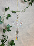 Aurinkosieppari, kuu ja aurinko, keskellä kristallikoriste.