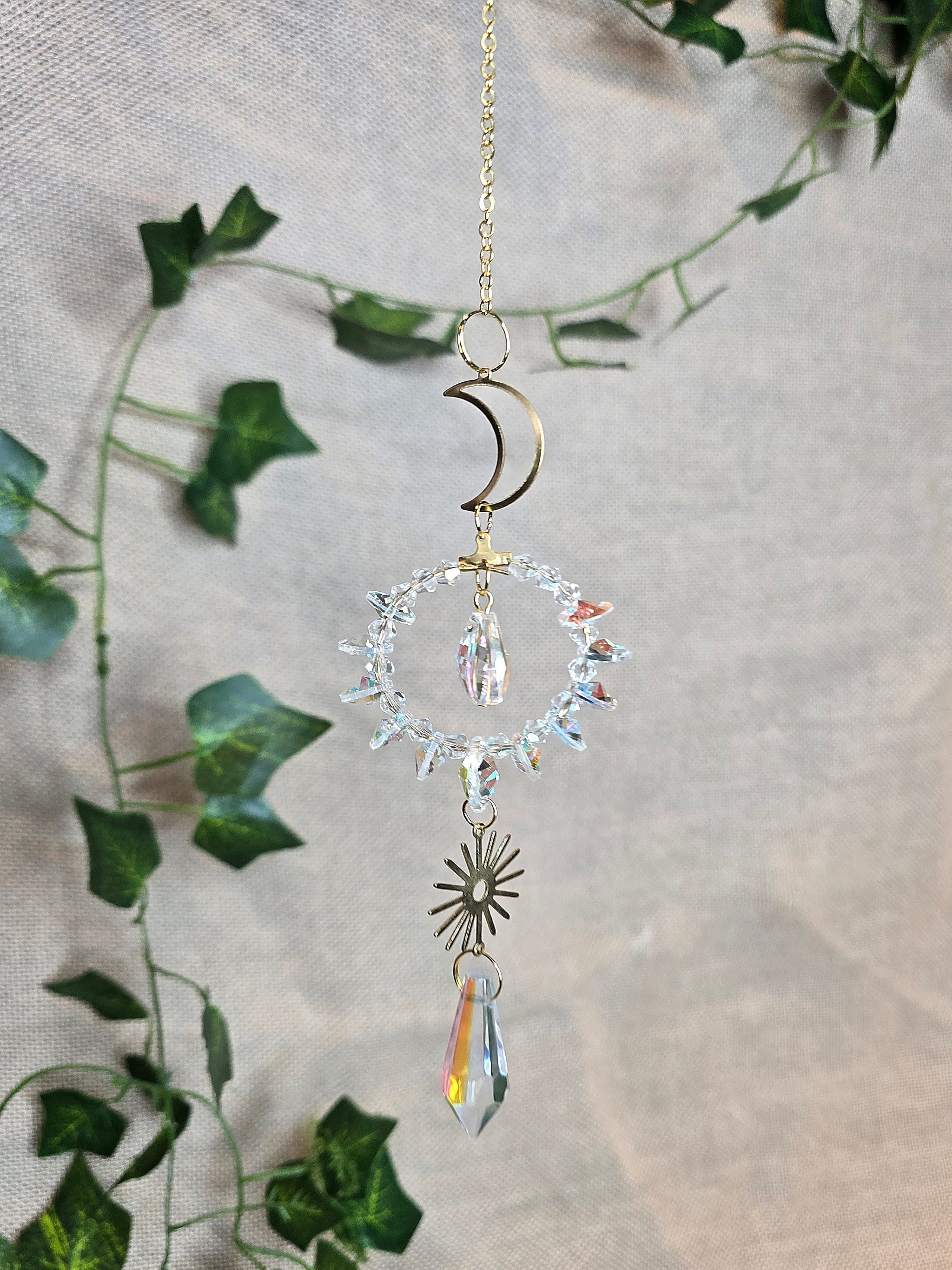 Aurinkosieppari, kuu ja aurinko, keskellä kristallikoriste.