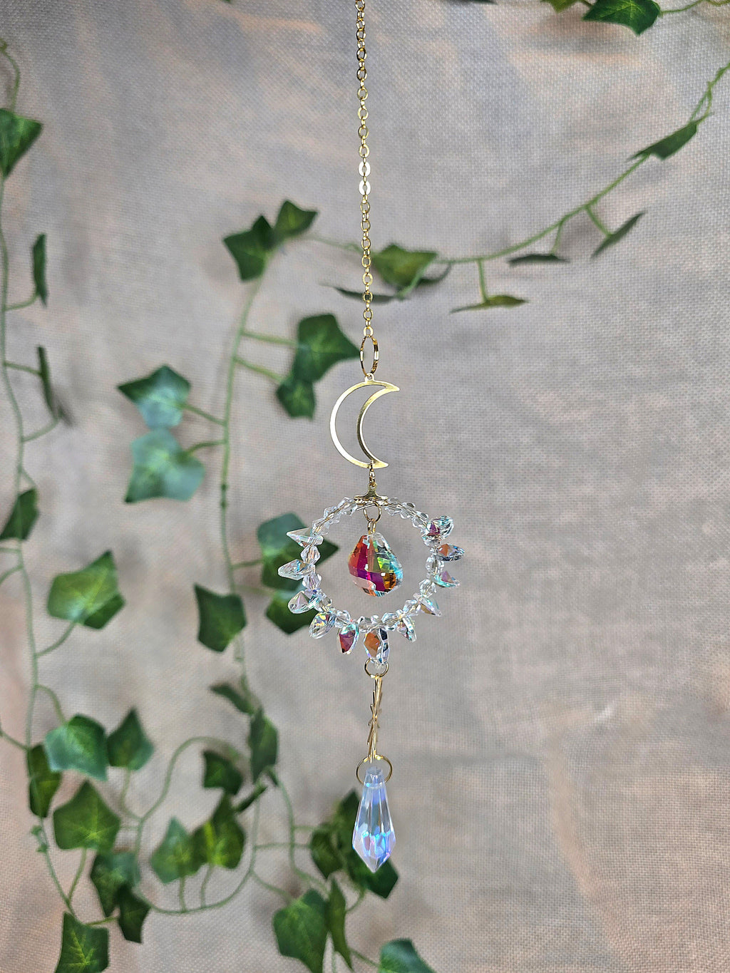 Aurinkosieppari, kuu ja aurinko, keskellä kristallikoriste.