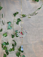 Aurinkosieppari, kuu ja aurinko, keskellä kristallikoriste.