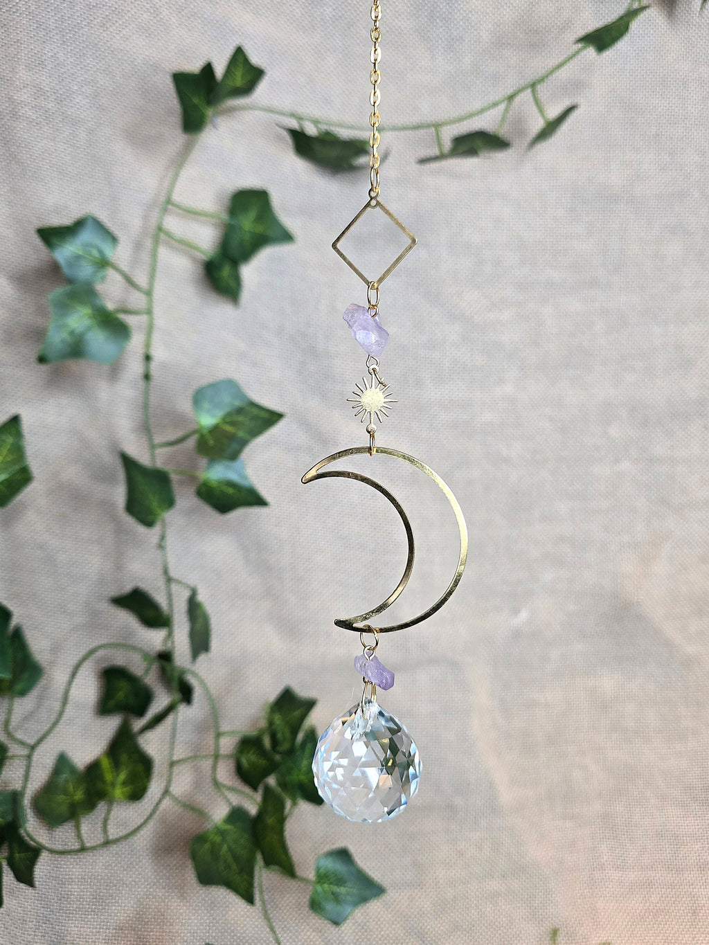 Kuunvalo aurinkosieppari, jossa lasikristalli, iso kuu somiste ja pienempi aurinko somiste.