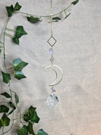 Kuunvalo aurinkosieppari, jossa lasikristalli, iso kuu somiste ja pienempi aurinko somiste.