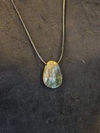 Labradoriitti kaulakoru nahkanauhassa. 