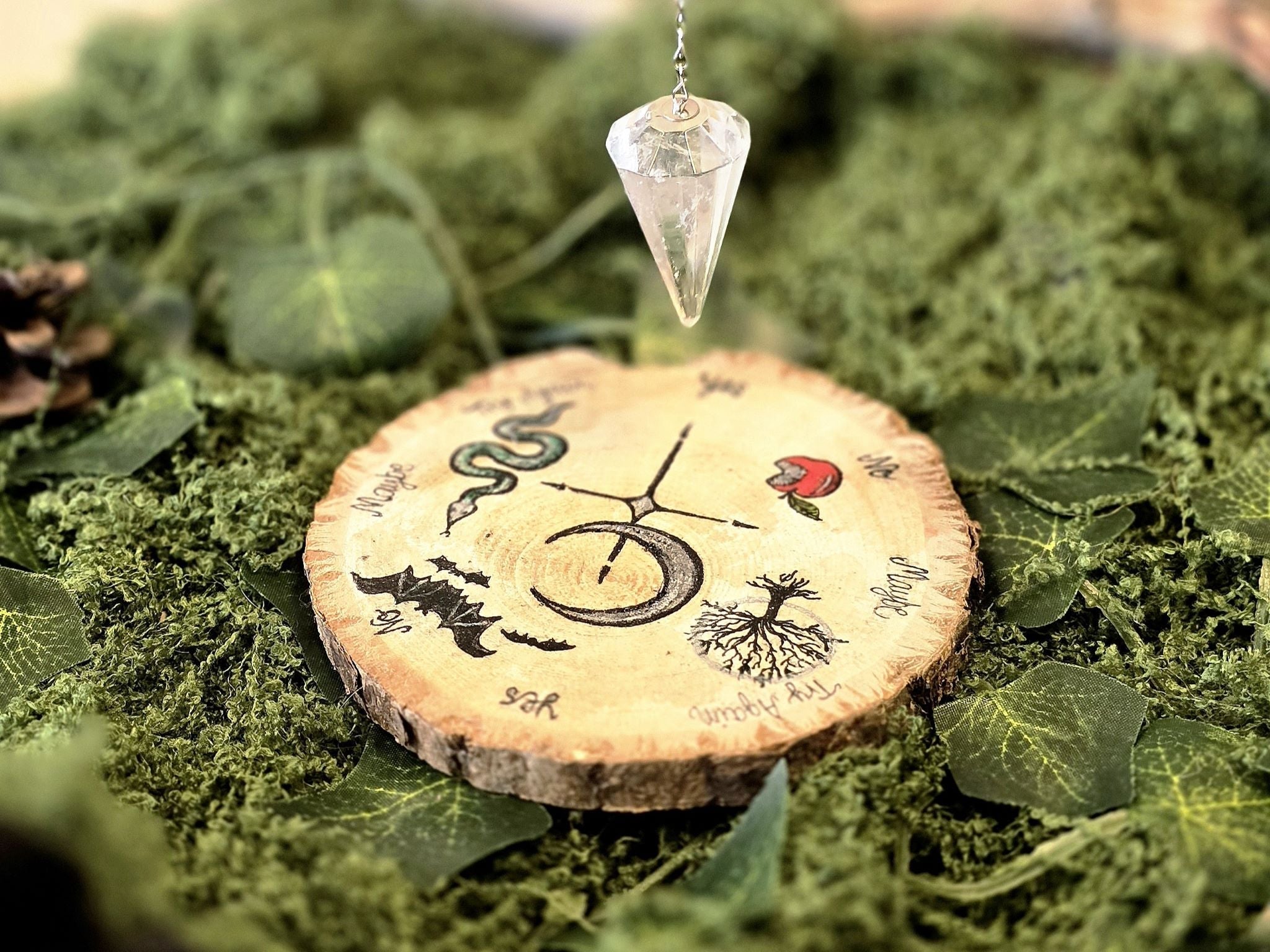 Puusta valmistettu heilurialusta Lilith jumalattaren symboliikalla. 